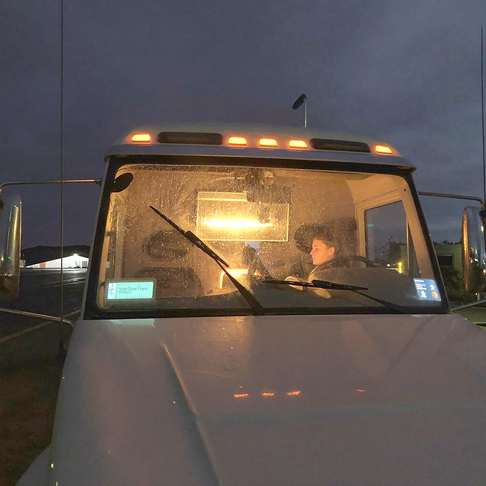 Truck cab glowing warm at night in a quiet truck stop